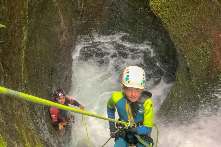 a person repelling down a waterfall